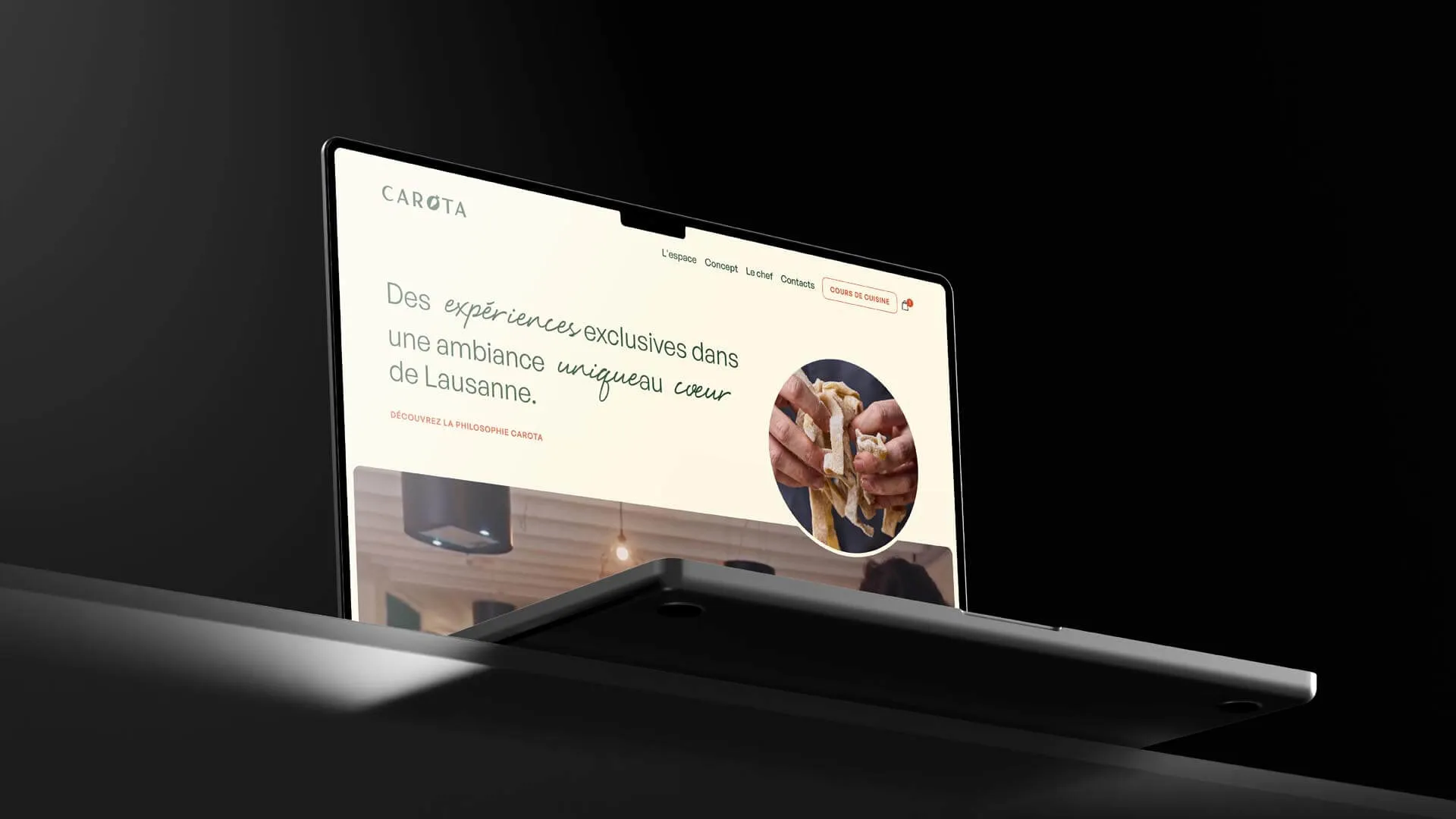 Laptop screen displaying a website in French titled CAROTA with a cooking theme, showing hands stretching dough and menu options.