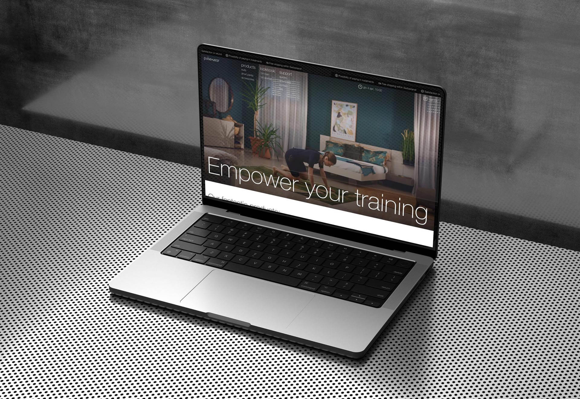 Open laptop on a perforated surface displaying a webpage with a woman exercising in a living room and the text 'Empower your training'.