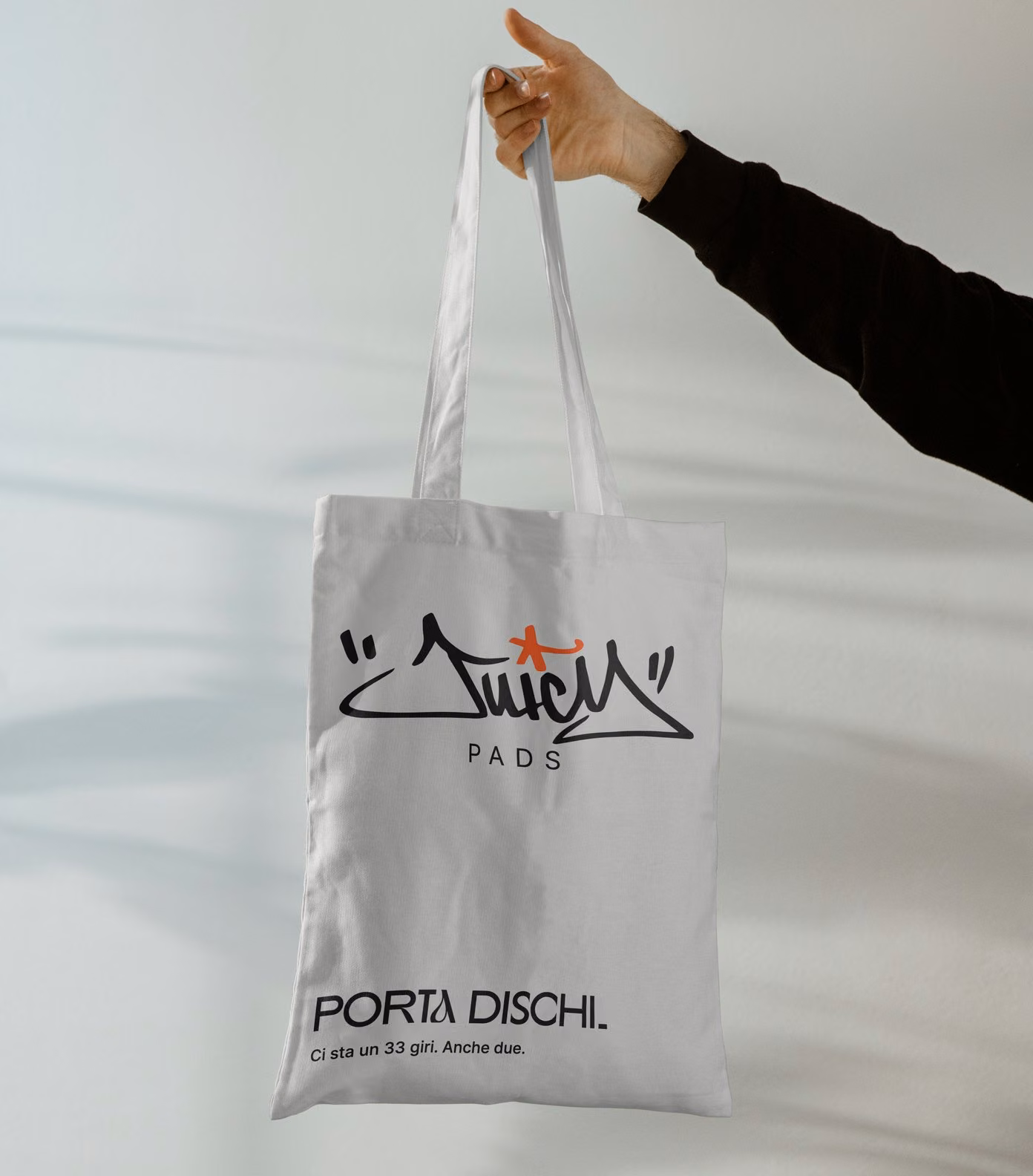 Grey Juicy Pads tote bag with the black tag and the orange star on the i: carries records