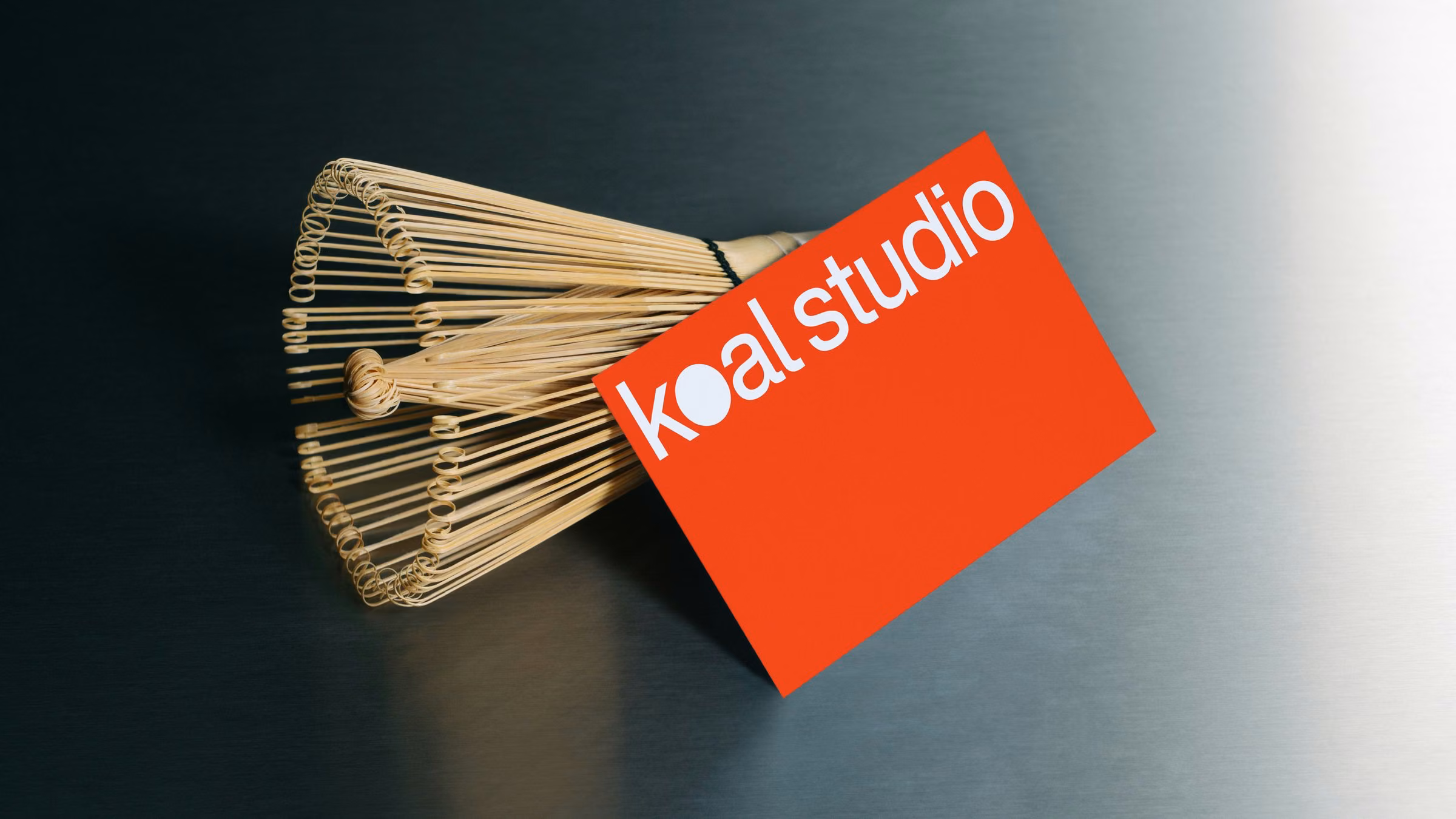 Red Koal Studio business card leaning on a whisk