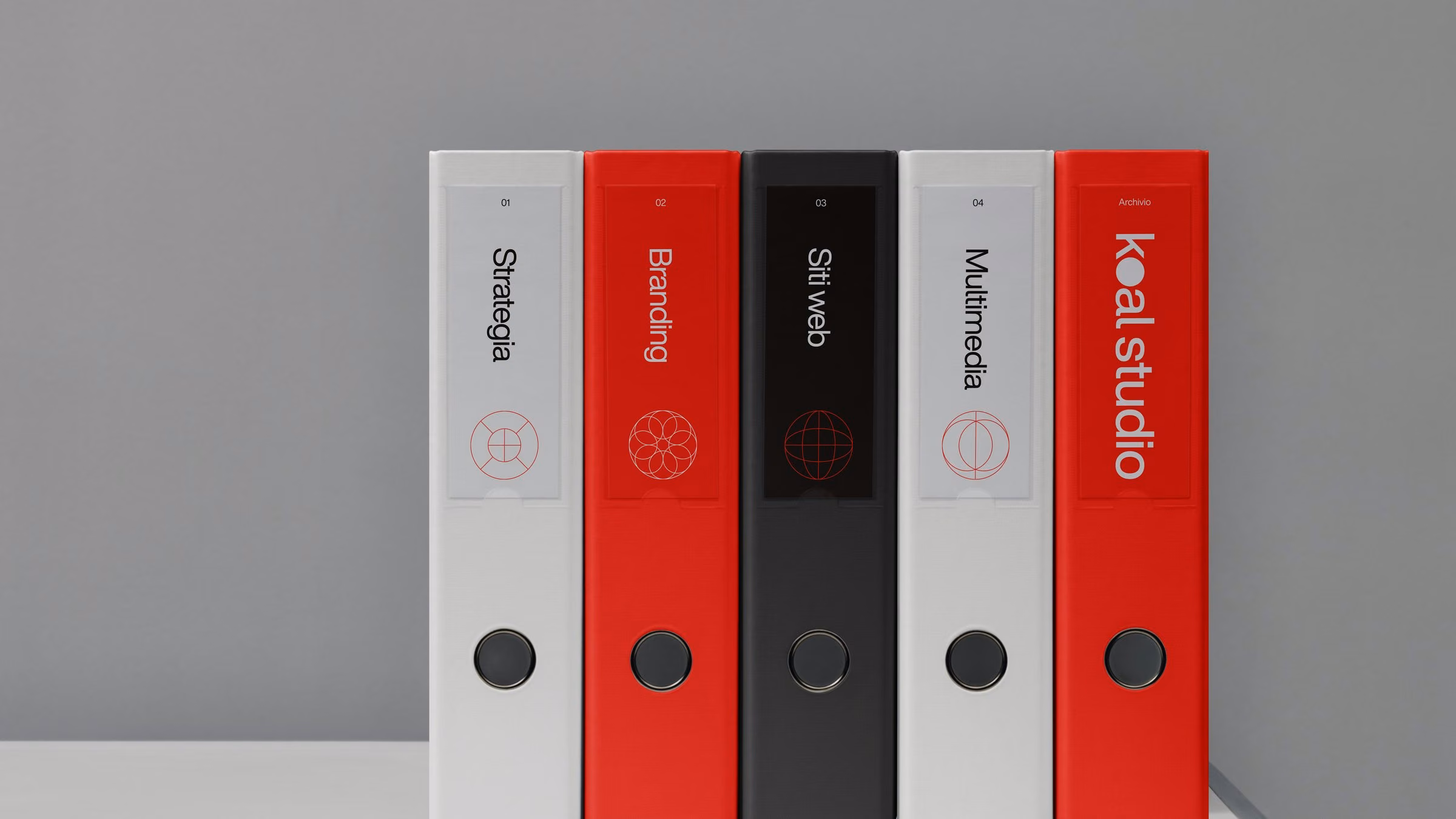 Koal Studio binders on a shelf, one per service: strategy, branding, websites, multimedia, and the archive