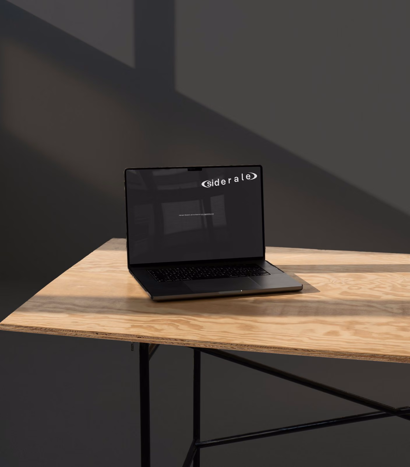 siderale.ch on a laptop, black contact page