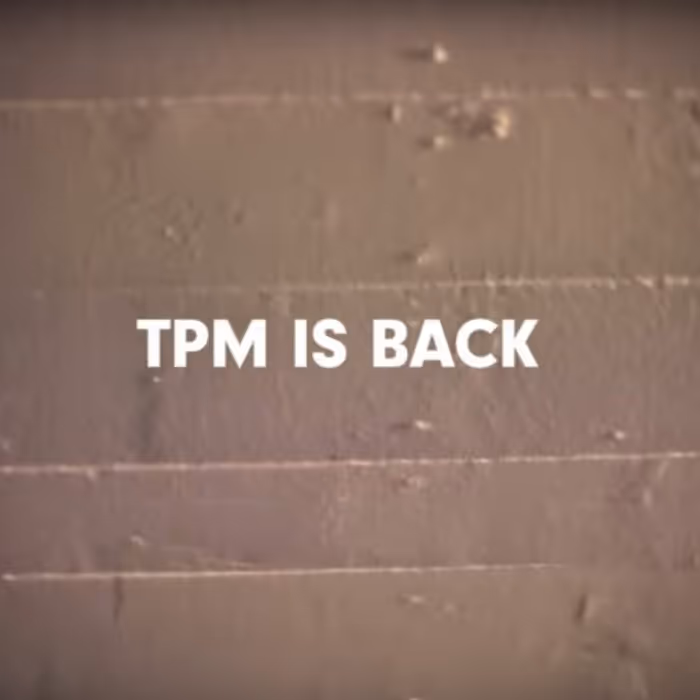 White text reading 'TPM IS BACK' on a textured brown wall background.