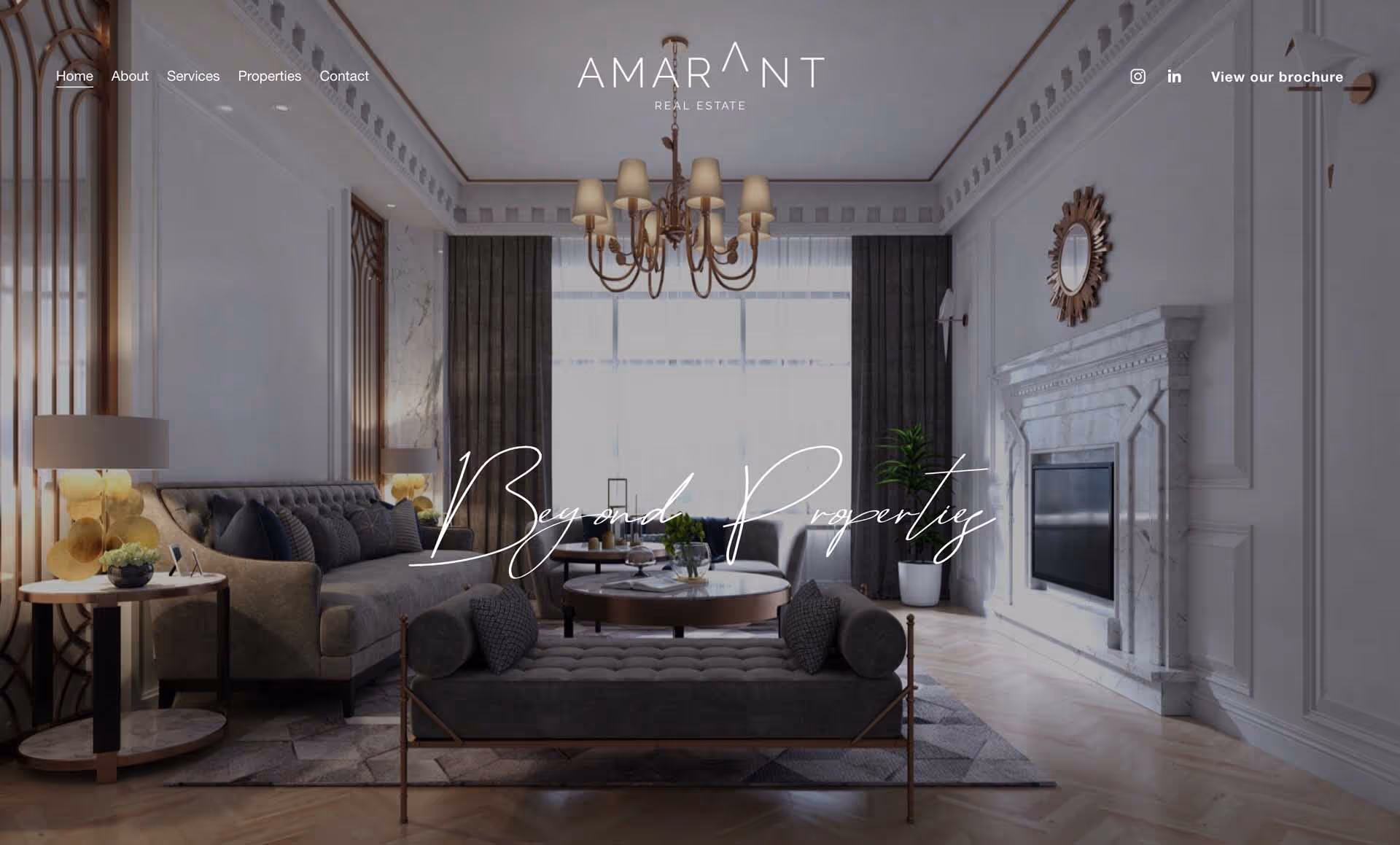 Elegant living room with tufted gray sofa, matching bench, marble fireplace, and chandelier.