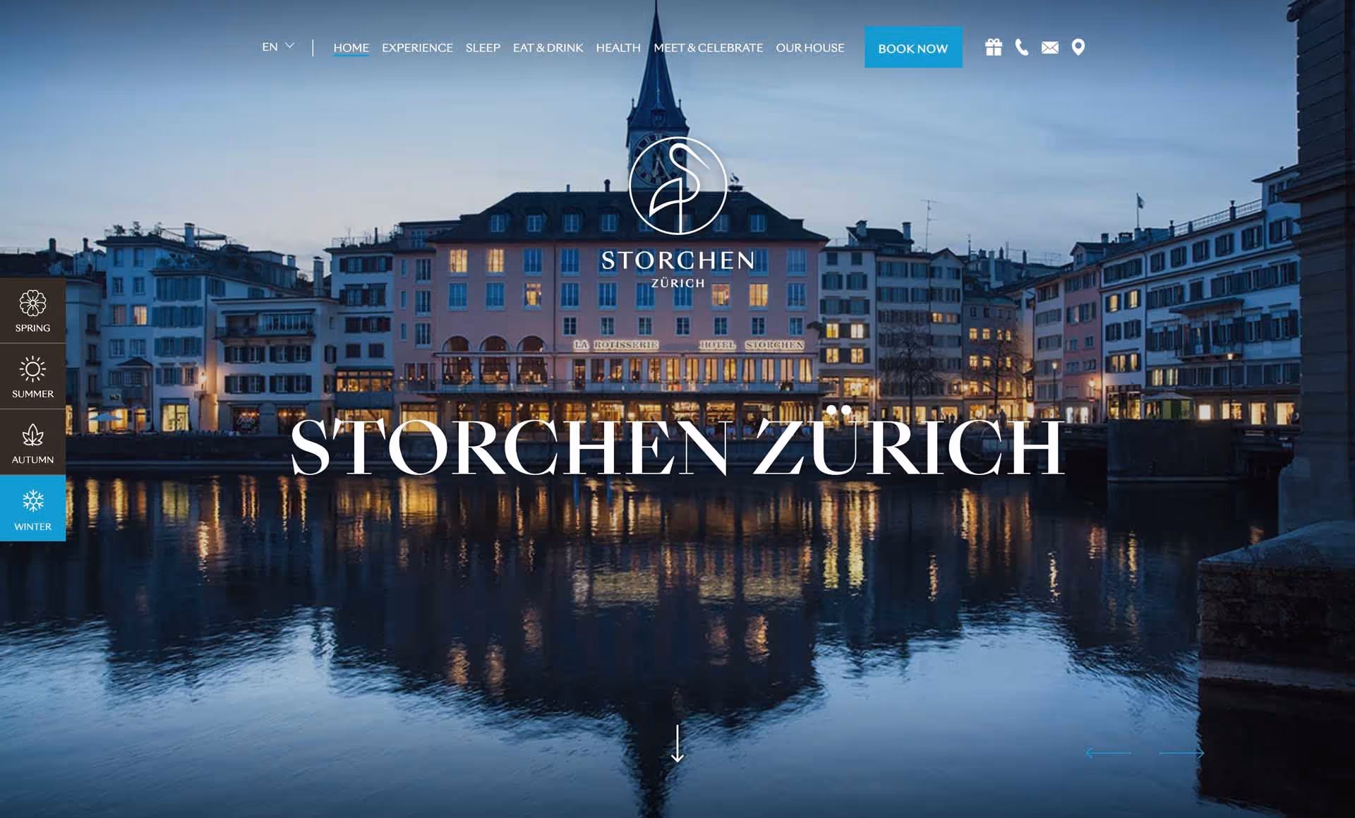 Evening view of historic buildings lit up along a river in Zurich, with their reflection shimmering on the water.