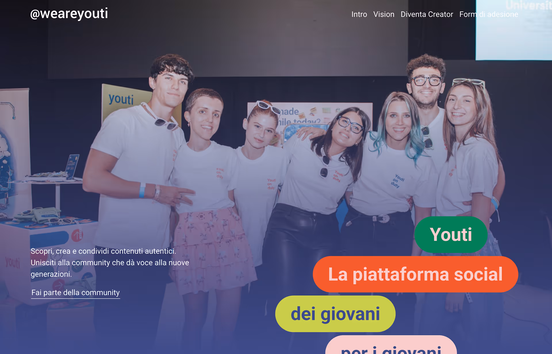Group of seven young adults smiling and posing together wearing matching white Youti on duty t-shirts at a social event.