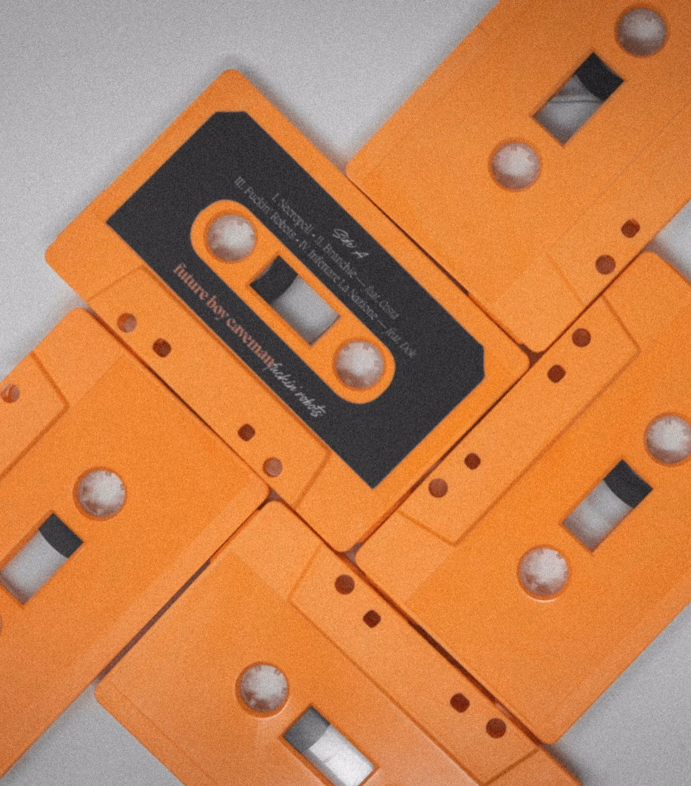 Orange cassettes of Fuckin' Robots by Future Boy Caveman