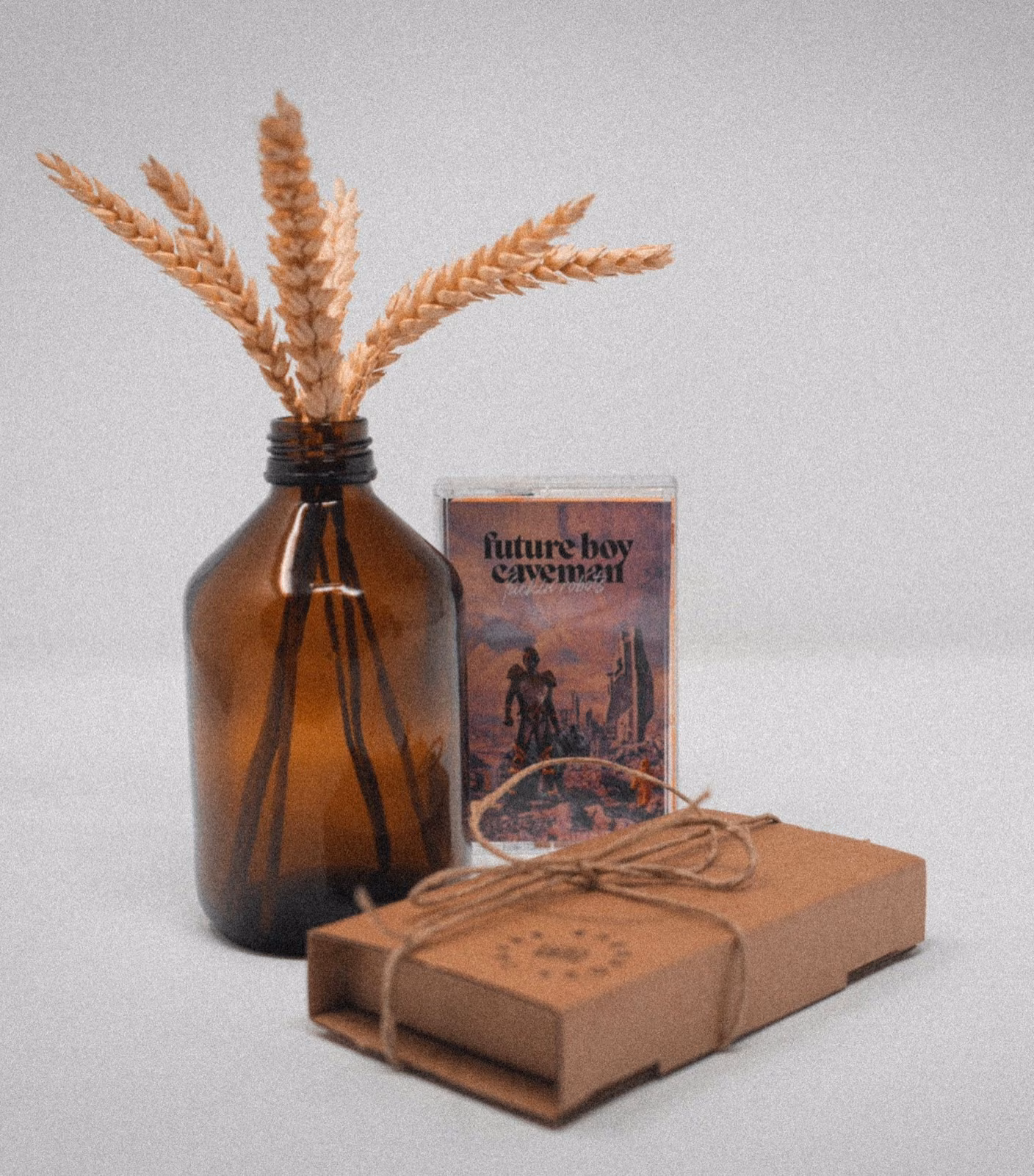 A cassette in its kraft box next to dried wheat