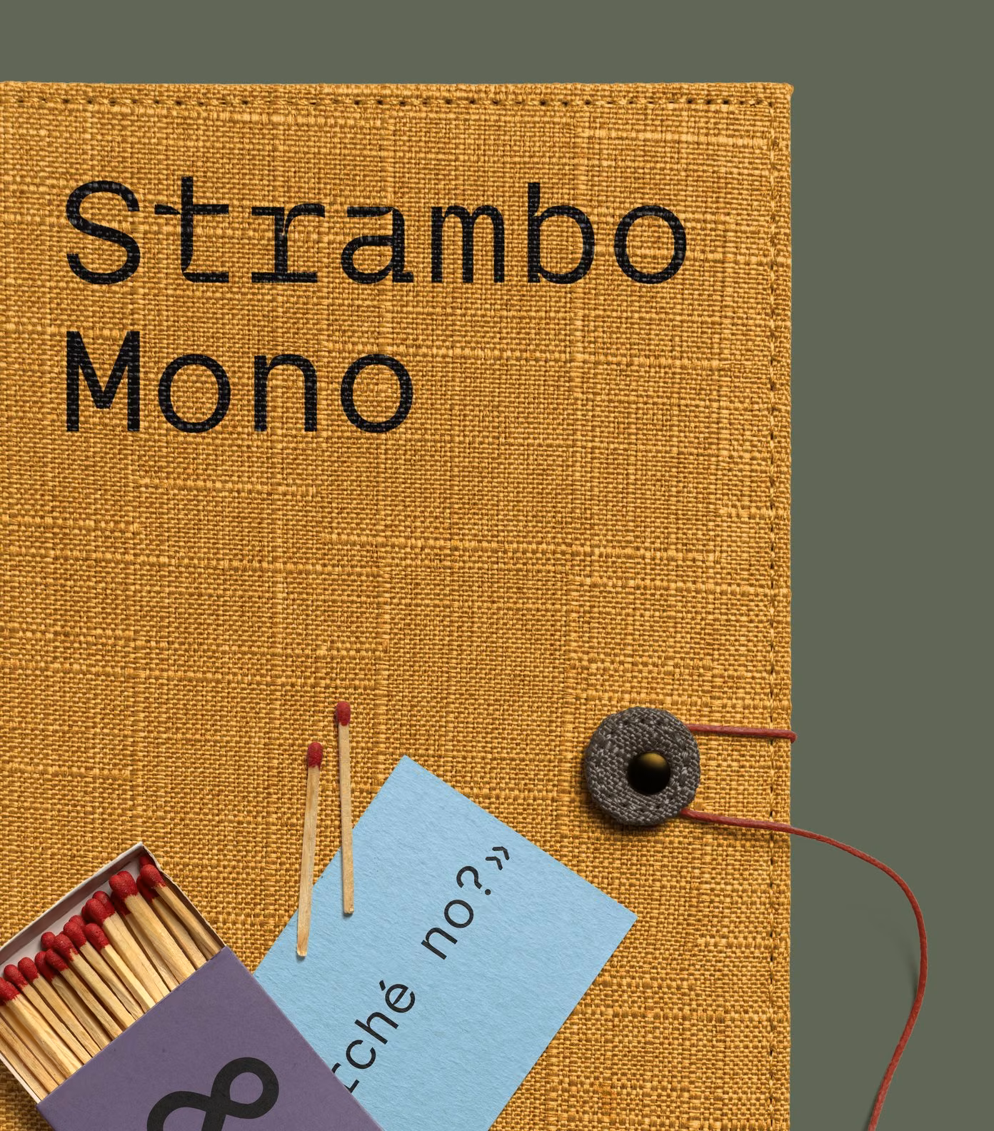 A mustard linen notebook, a light blue card with «Perché no?» and a box of matches with the ampersand